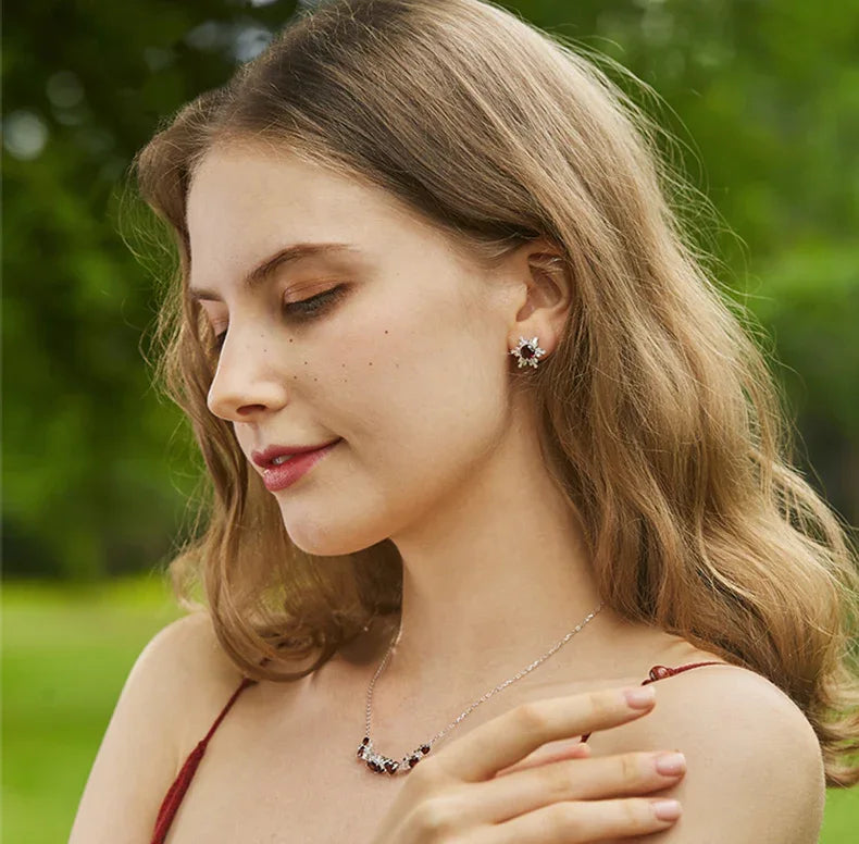 Garnet Snowflake Halo Stud Earrings worn on the hand from a second angle
