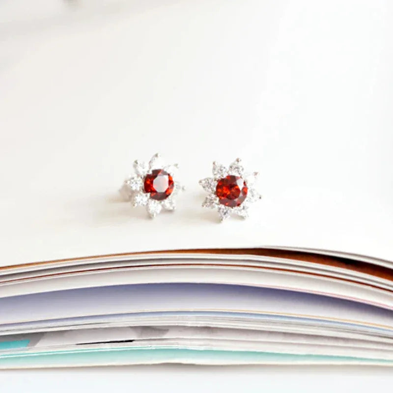 Garnet Snowflake Stud Earrings side view held between the fingers