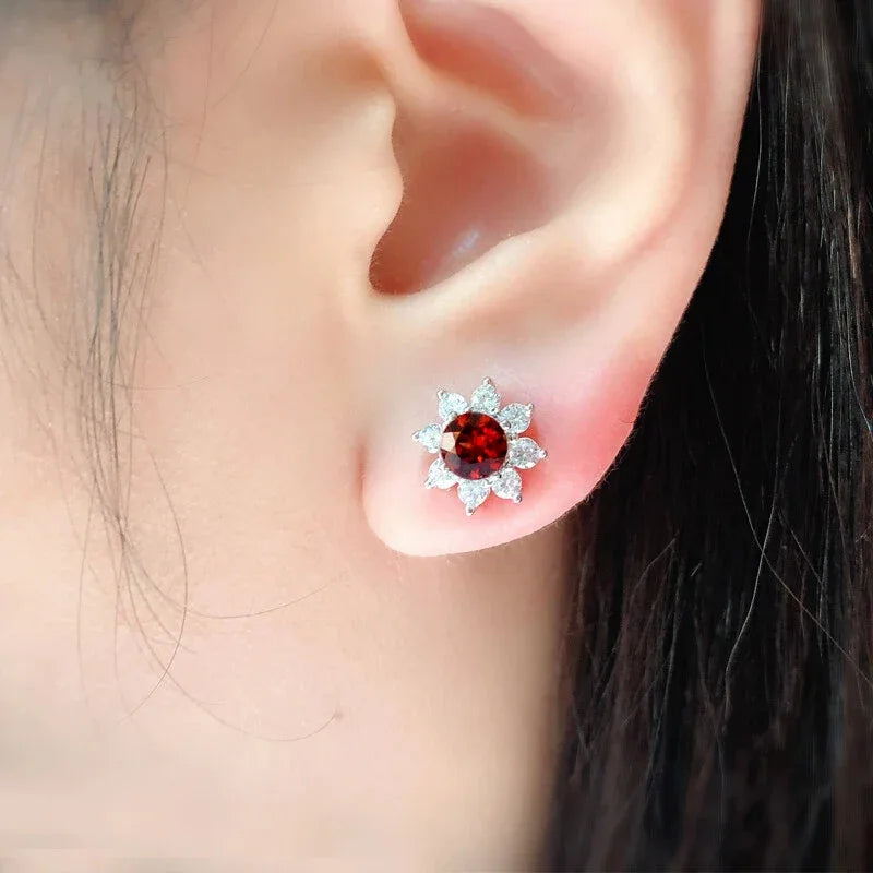 Garnet Snowflake Stud Earrings worn on the hand in a close-up