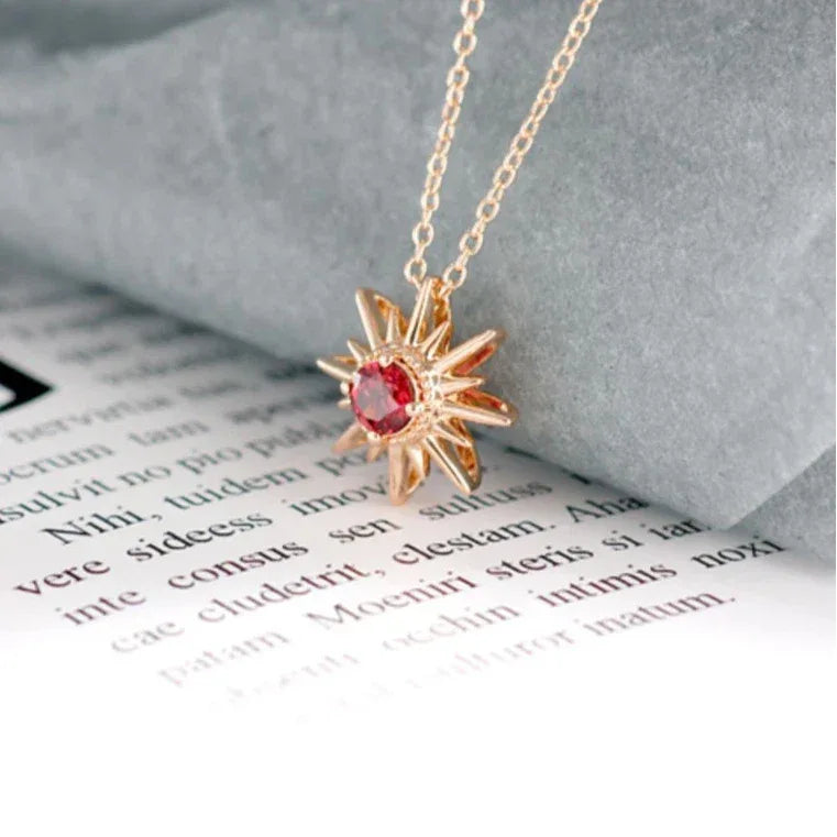 Garnet Sunburst Pendant Necklace pendant styled on a jewelry display