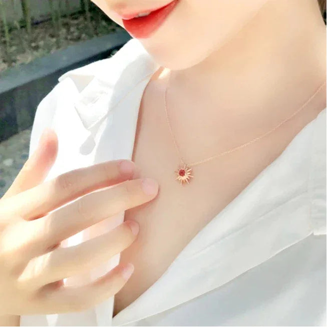 Garnet Sunburst Pendant Necklace worn at the neckline from a second angle
