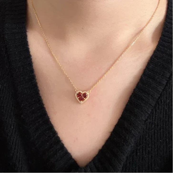 Garnet Triple-Stone Heart Necklace worn at the neckline in a close-up