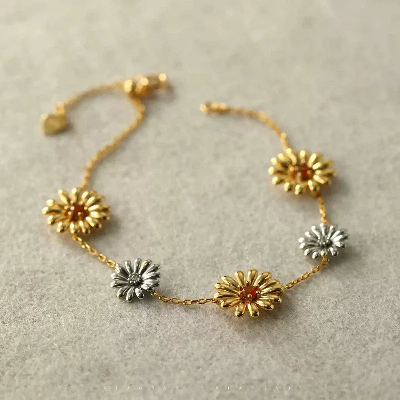 Garnet Two-Tone Floral Station Bracelet bracelet arranged on a jewelry display