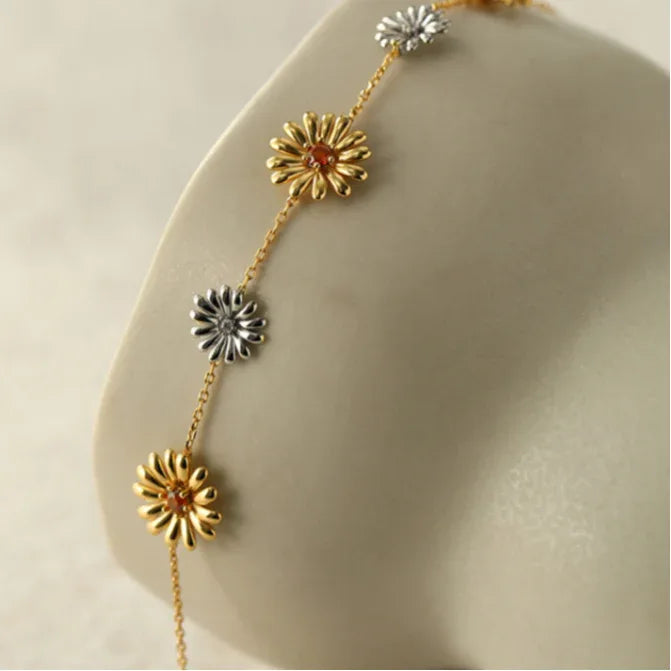 Garnet Two-Tone Floral Station Bracelet worn on the wrist in a close-up