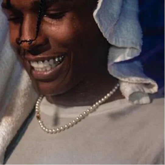 Classic Pearl Strand Necklace — smiling model wearing the necklace over a gray top