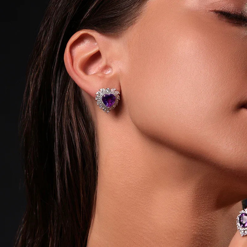 heart-cut amethyst stud earrings worn on the ear in a close-up