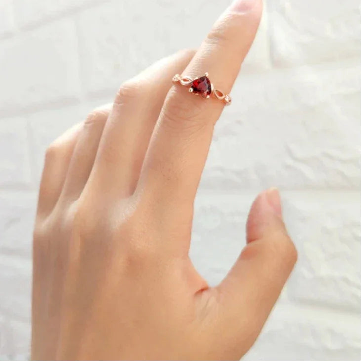Heart-Cut Garnet Adjustable Ring side view held between the fingers