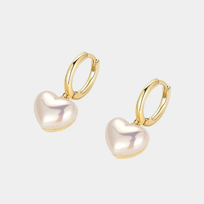 Pearl Heart Drop Huggie Earrings — front pair of gold-tone huggie hoops with pale heart pearl drops