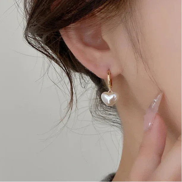 Pearl Heart Drop Huggie Earrings — side worn view with the heart below the earlobe