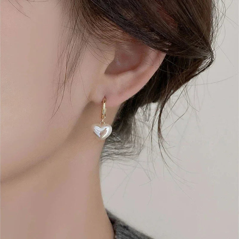 Pearl Heart Drop Huggie Earrings — alternate right-ear worn view