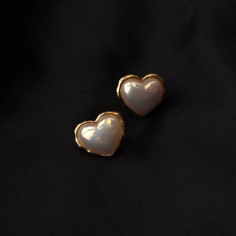 Heart-Shaped Pearl Stud Earrings — pair displayed on a black background