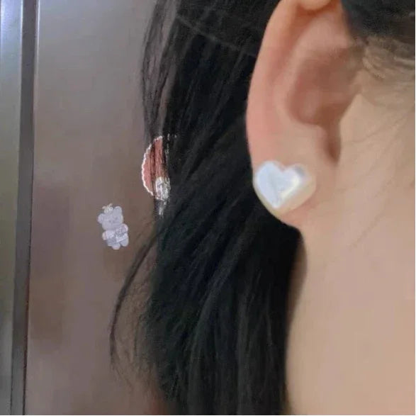 Iridescent Pearl Heart Stud Earrings — left-ear worn close-up