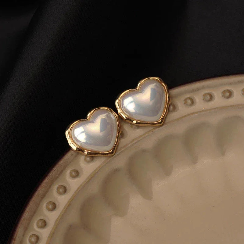 Heart-Shaped Pearl Stud Earrings — earrings displayed on a decorative plate