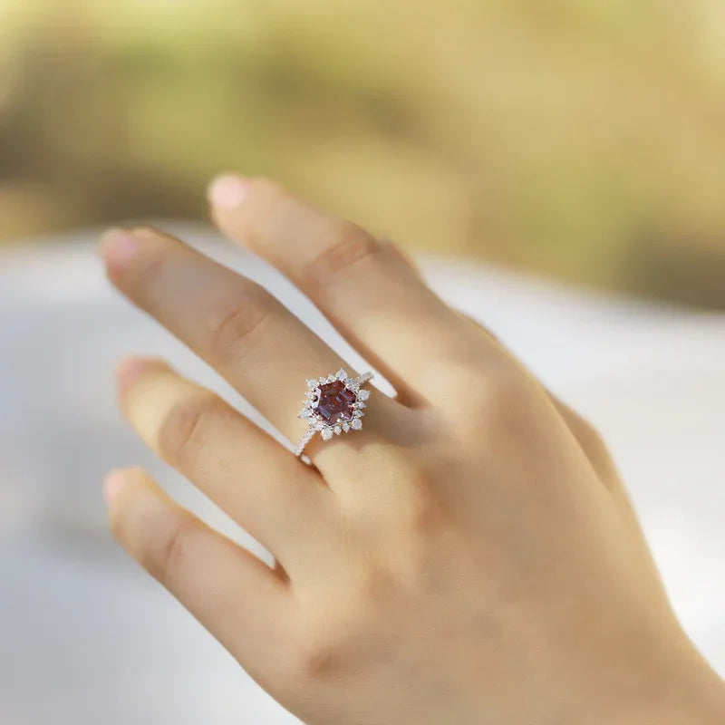Hexagon Alexandrite sunburst halo ring, shown worn in a close lifestyle view