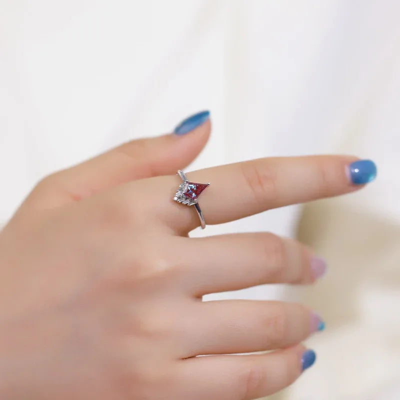 Kite-cut Alexandrite ring with a clear drop accent, shown worn in a close lifestyle view