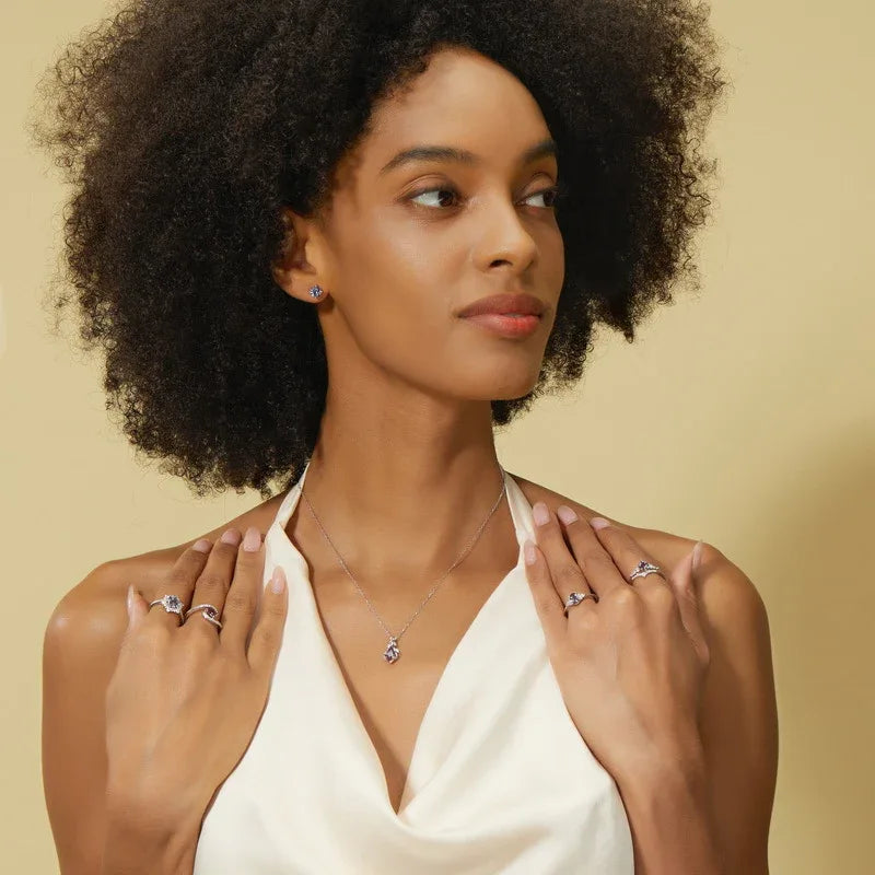 Kite-cut Alexandrite drop necklace with an open silver-tone frame, shown worn by a model for scale
