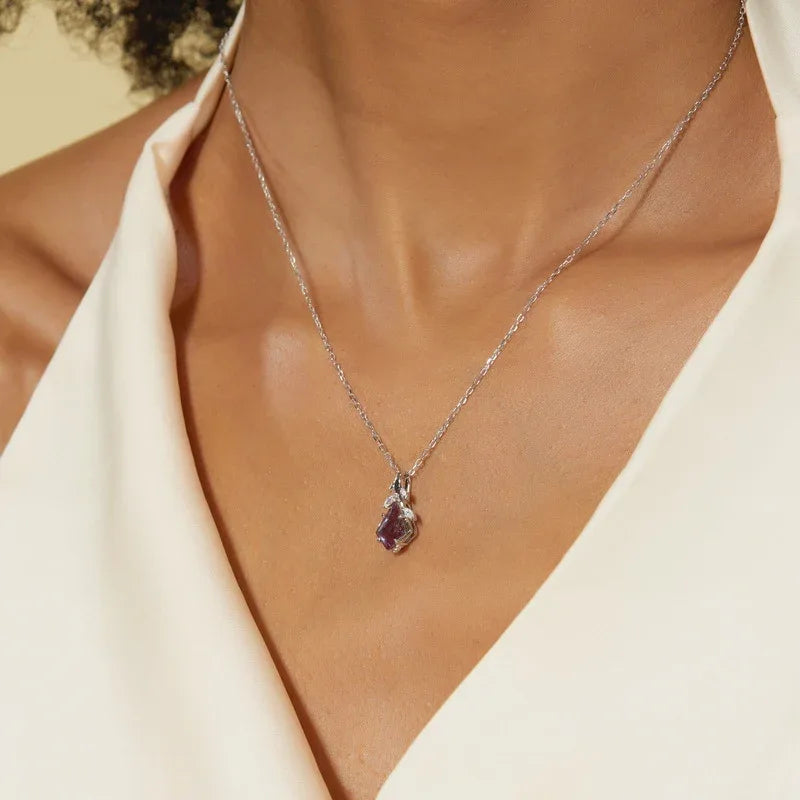 Kite-cut Alexandrite drop necklace with an open silver-tone frame, shown worn in a close lifestyle view