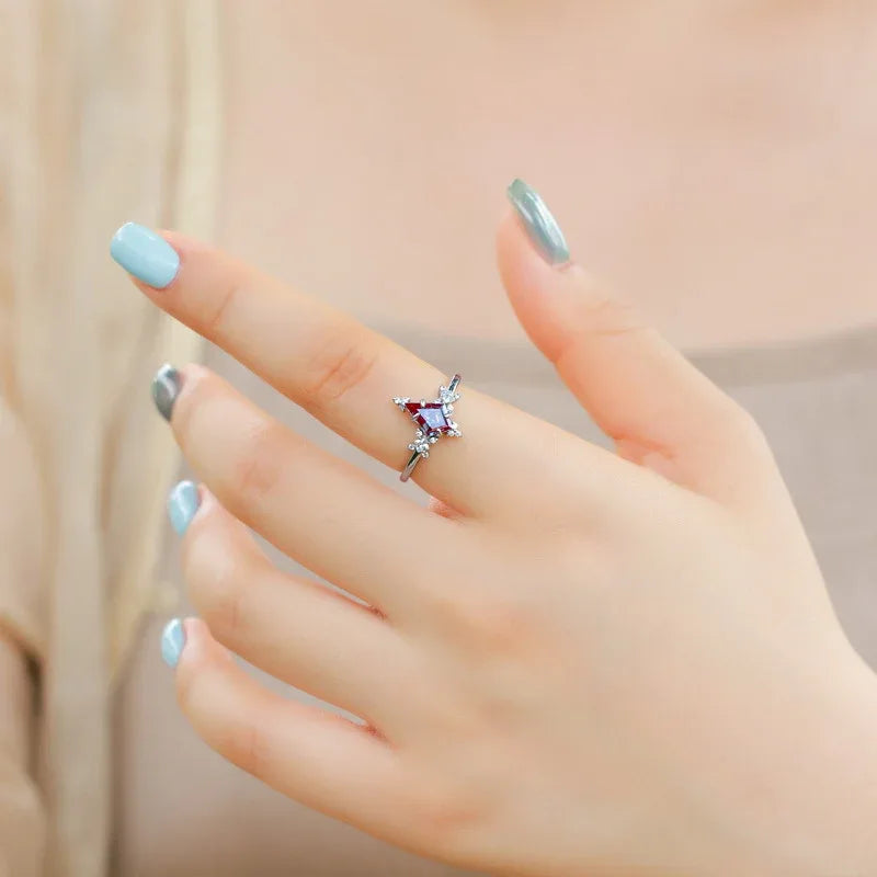 Kite-cut Alexandrite ring with clear halo accents, shown worn in a close lifestyle view