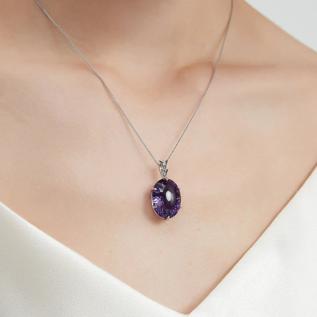 large oval amethyst pendant necklace worn at the neckline in a close-up
