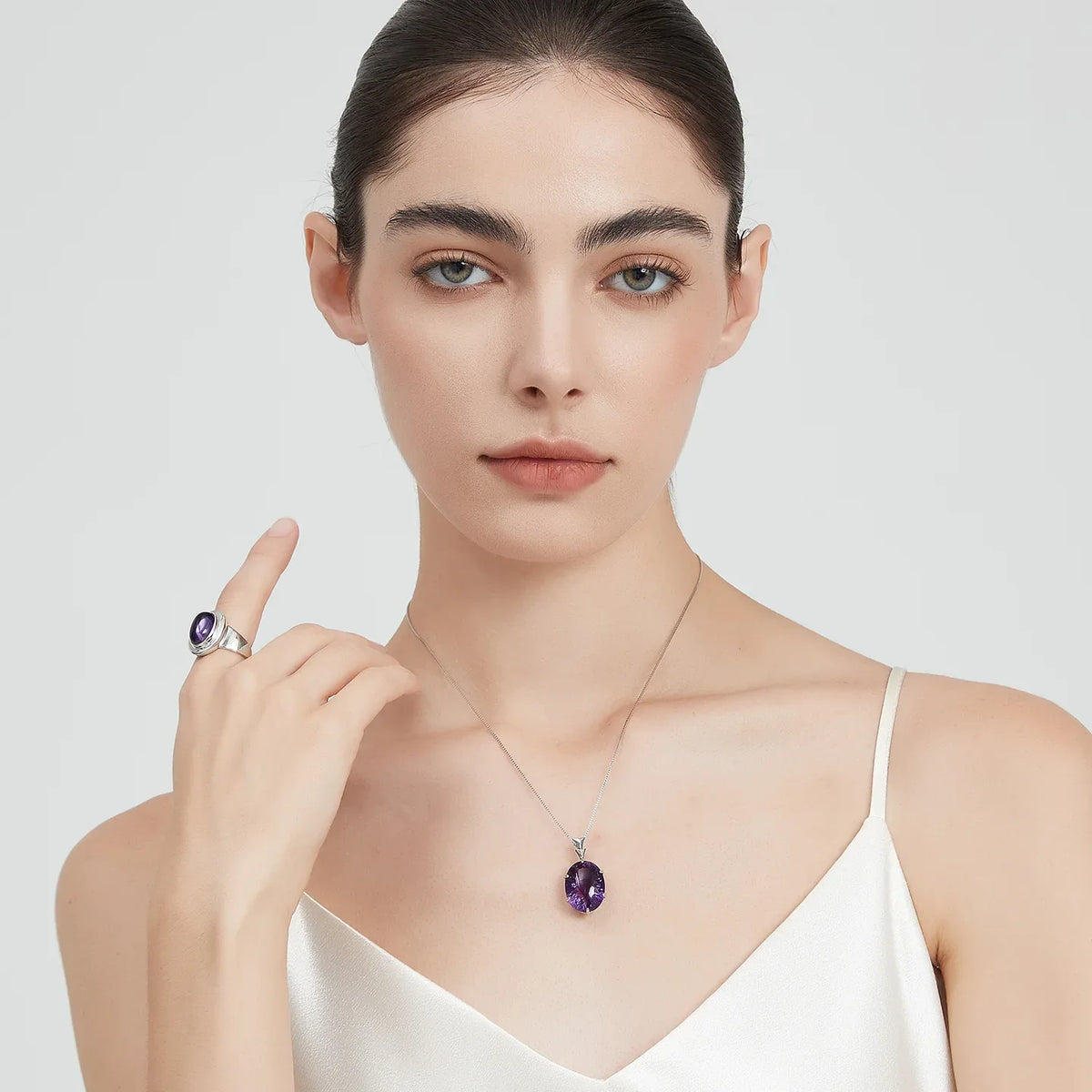 large oval amethyst pendant necklace worn at the neckline in a portrait