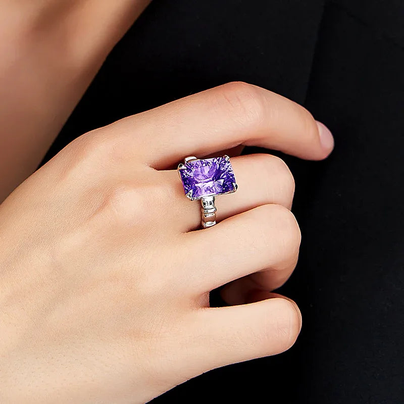 rectangular amethyst solitaire ring worn on the hand in a close-up