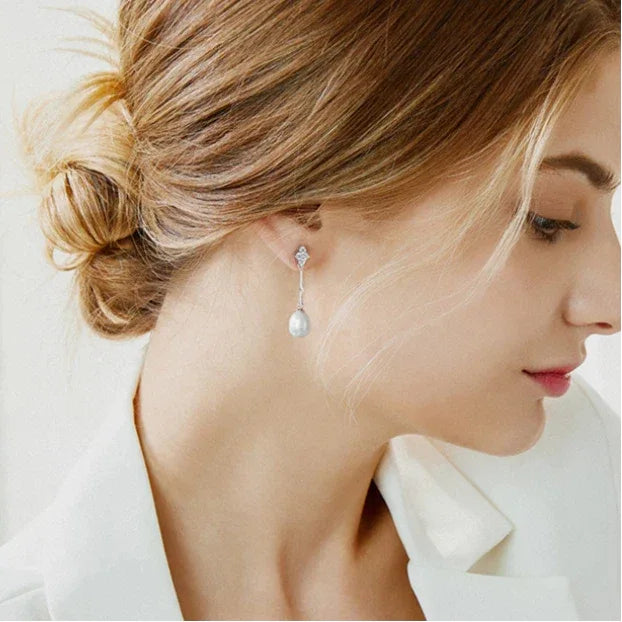 Teardrop Pearl Linear Earrings in Platinum-Plated S925 Silver — left-ear worn portrait showing the full drop length