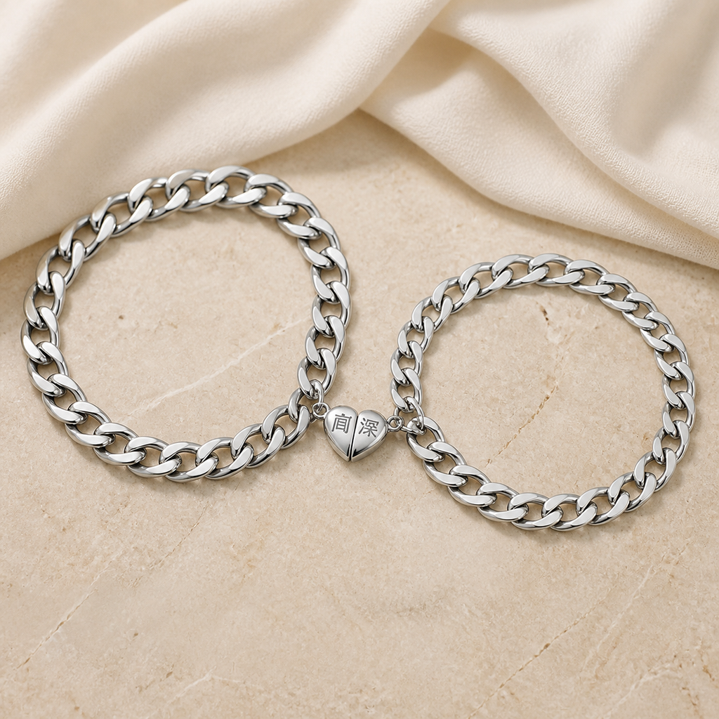 Two silver-tone curb-chain bracelets joined by matching magnetic heart halves on beige stone