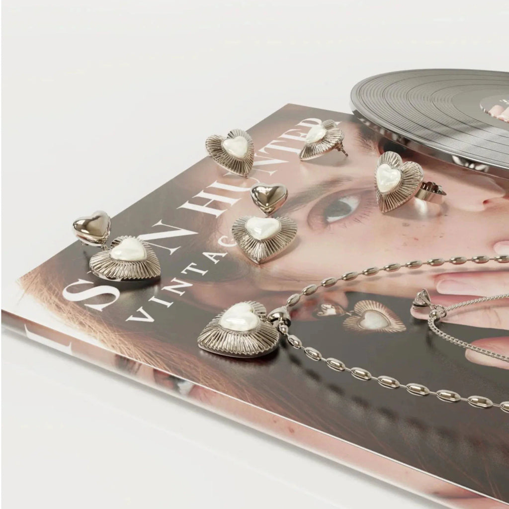 Double-Layer Pearl Heart Necklace — coordinated jewelry display on a book and tray