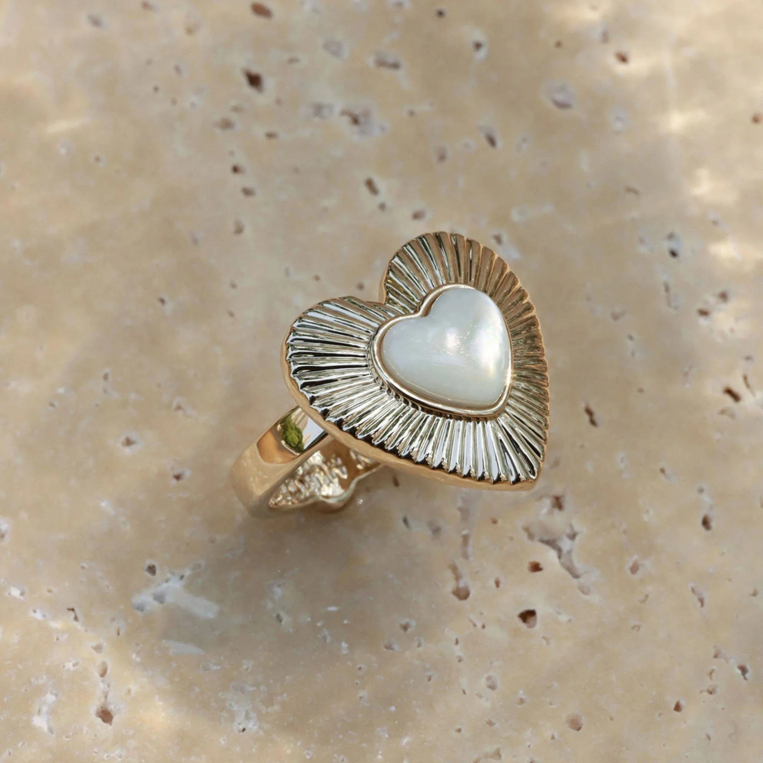 Ridged Pearl Heart Open Ring — top view on a pale stone surface