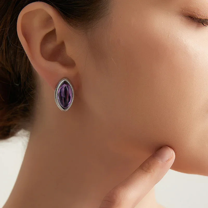 marquise amethyst stud earrings worn on the ear in a close-up
