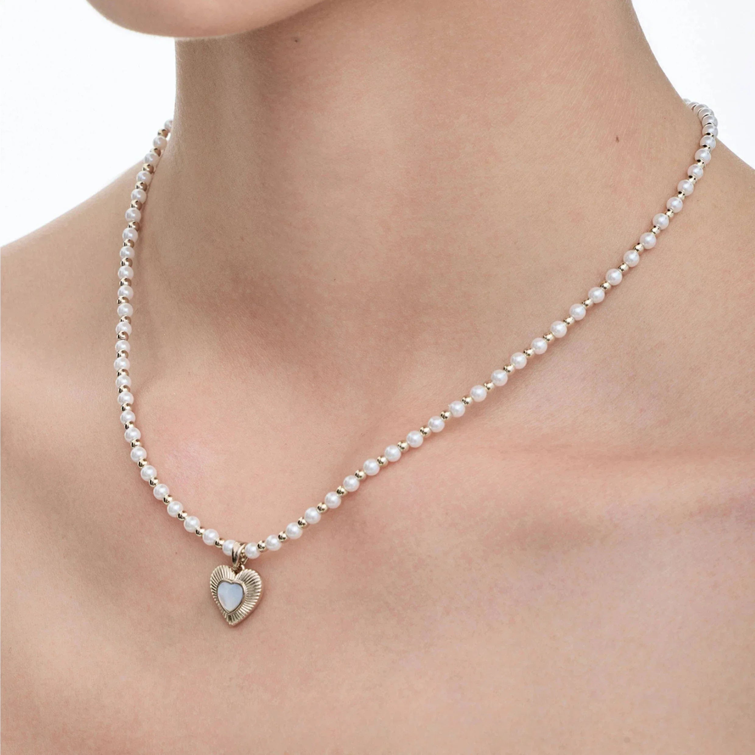 Pearl Bead Necklace with Petite Ridged Heart — alternate worn view showing the bead strand