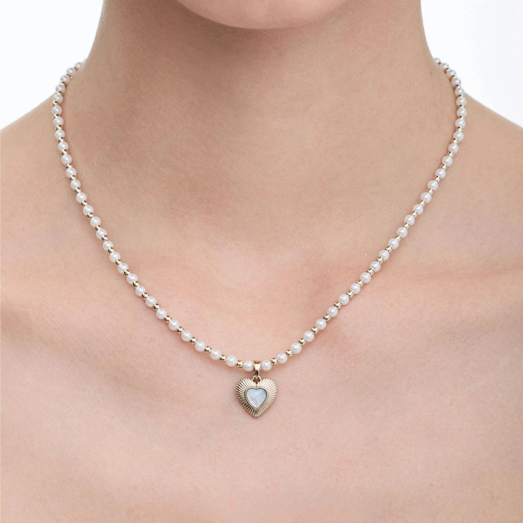 Pearl Bead Necklace with Petite Ridged Heart — front neckline-worn close-up showing the compact heart scale