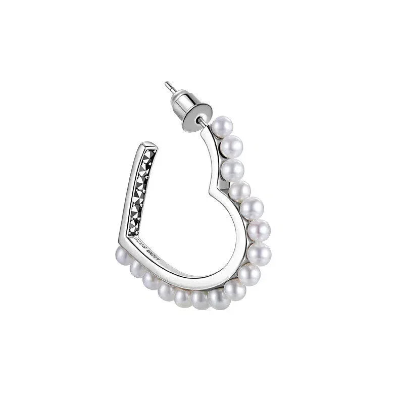 Pearl-Lined Open Heart Earrings — angled view of the pearl-lined outer curve and dark inset accent strip