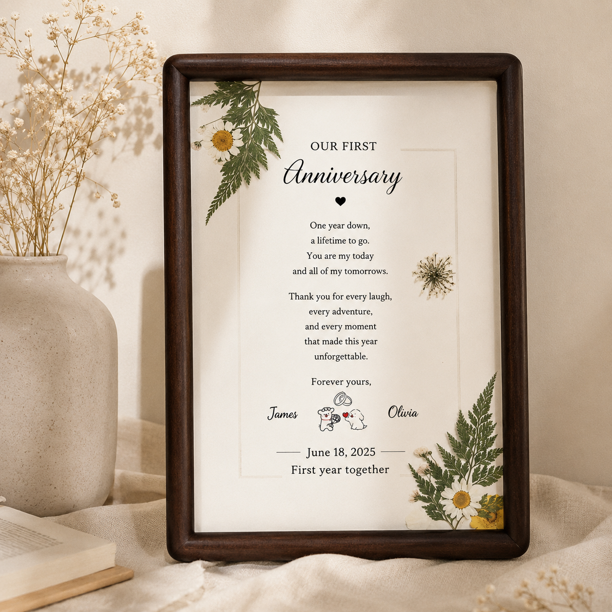 Our First Chapter personalized botanical anniversary frame freestanding on a walnut sideboard beside Kinfolk This Is