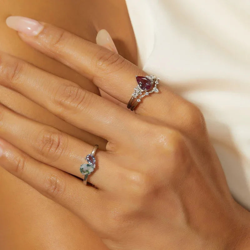 Oval Alexandrite cluster ring with a curved matching band, alternate shown worn in a close lifest, alternate angle 2