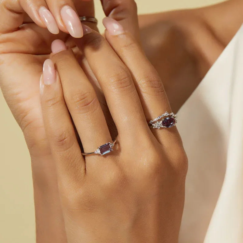 Oval Alexandrite floral three-band ring with clear accents, shown worn in a close lifestyle view