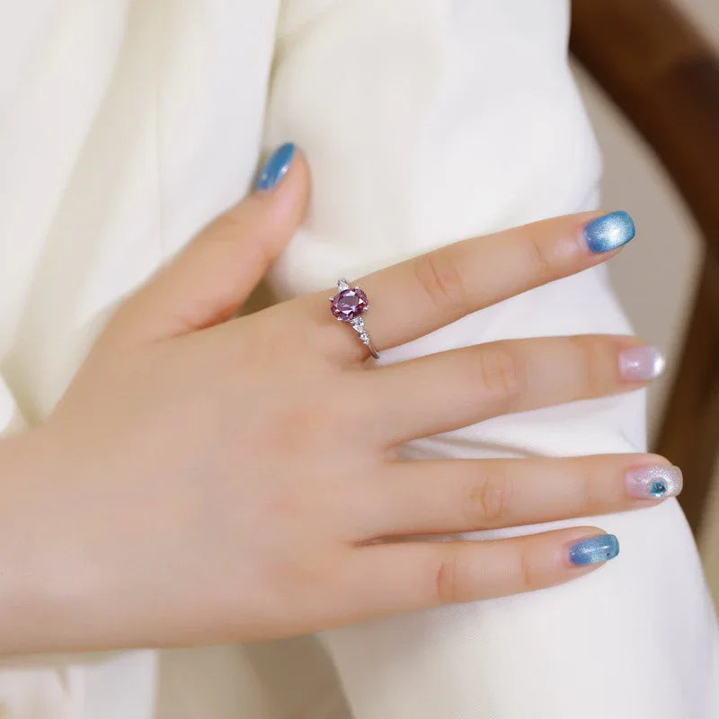 Oval Alexandrite leaf bypass ring with clear accents, shown worn in a close lifestyle view