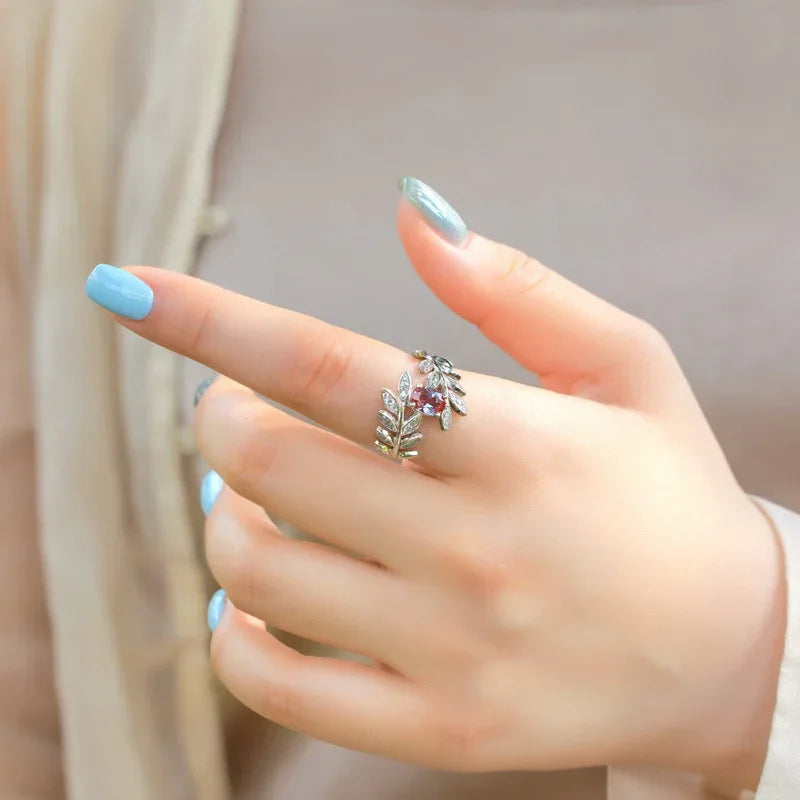 Oval Alexandrite leaf wrap ring with clear accents, shown worn in a close lifestyle view