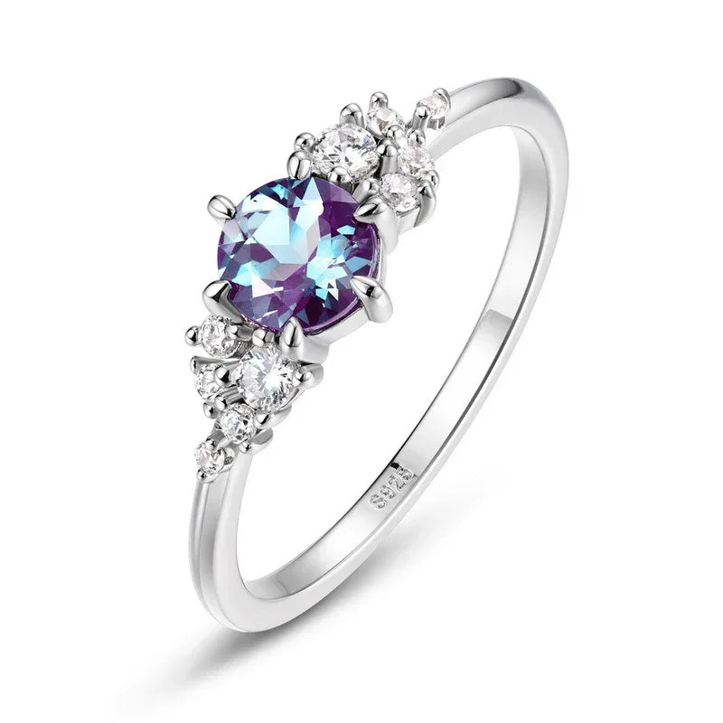 Oval Alexandrite ring with clear-stone side clusters, alternate front product view on a white background