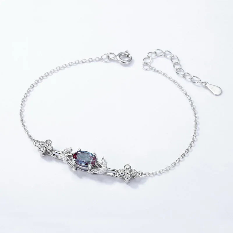 Oval Alexandrite station bracelet with clear accents, center stone close-up on a white background