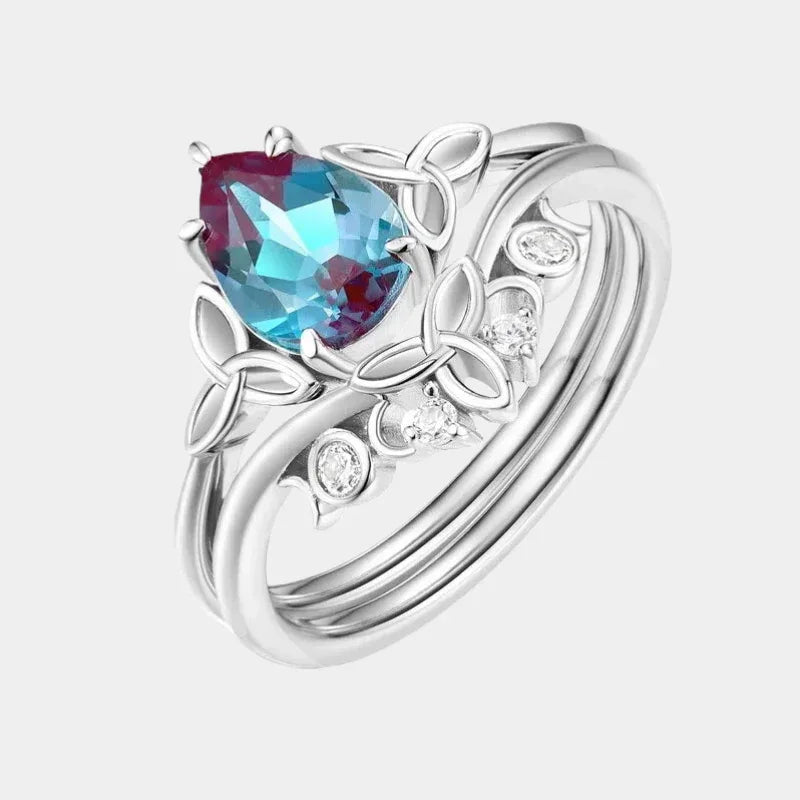 Oval Alexandrite three-band ring with leaf and clear-stone accents, front product view on a white background