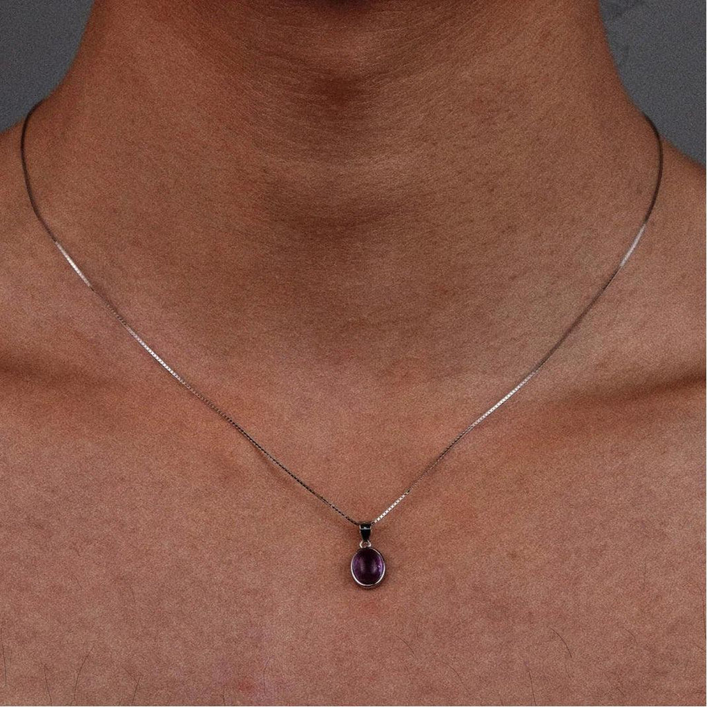oval amethyst cabochon necklace worn at the neckline in a close-up