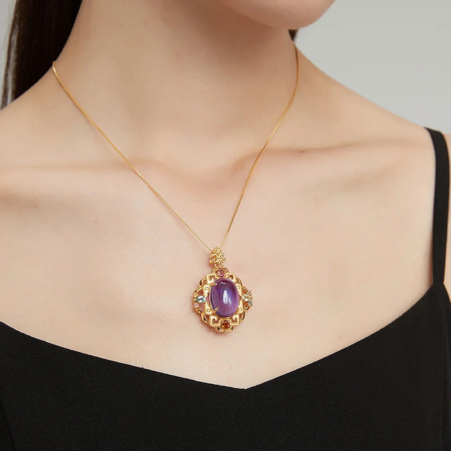 oval amethyst filigree pendant necklace worn at the neckline in a close-up