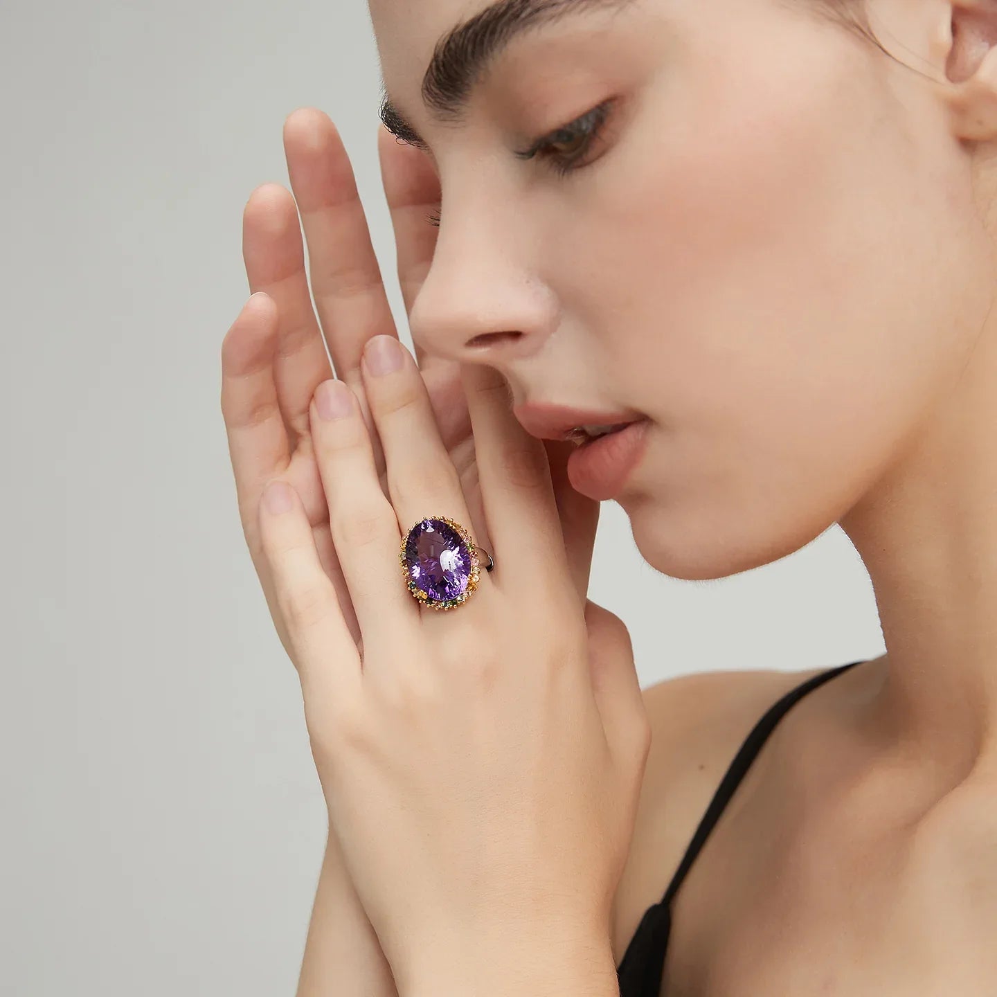 oval amethyst multigem ring worn on the hand from a second angle