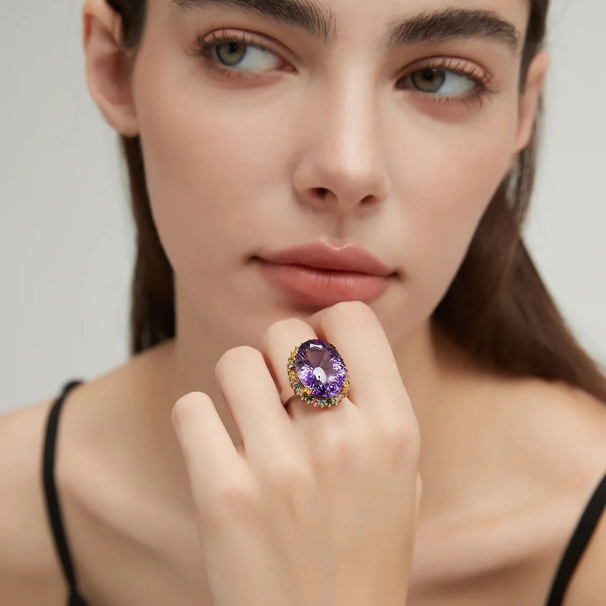 oval amethyst multigem ring worn on the hand in a close-up