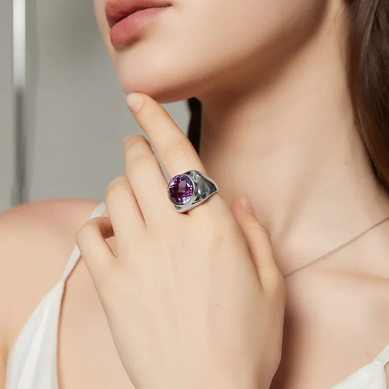 oval amethyst sculptural ring worn on the hand in a close-up