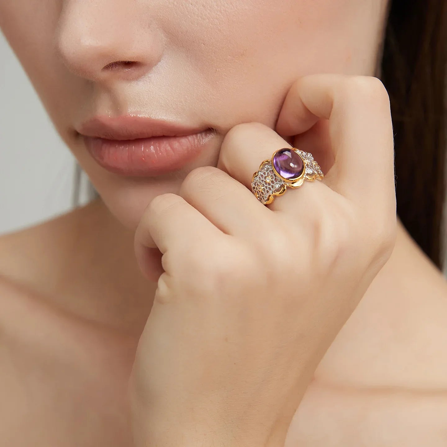 oval amethyst filigree ring worn on the hand in a close-up