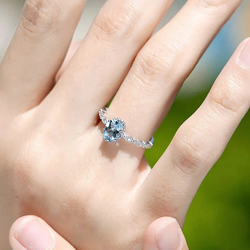 Oval Aquamarine Crown Accent Ring worn on the hand in a close-up