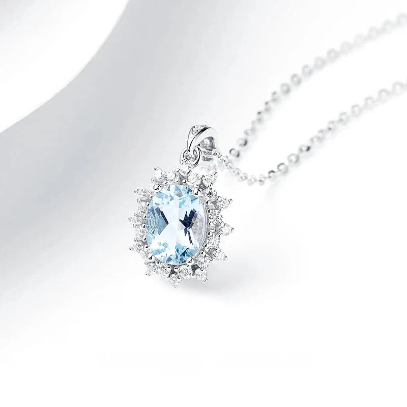 Oval Aquamarine Halo Pendant Necklace pendant and chain detail on a light background