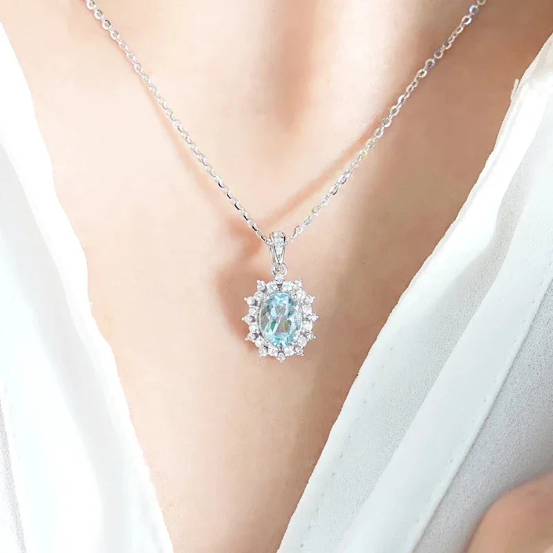 Oval Aquamarine Halo Pendant Necklace worn at the neckline in a close-up